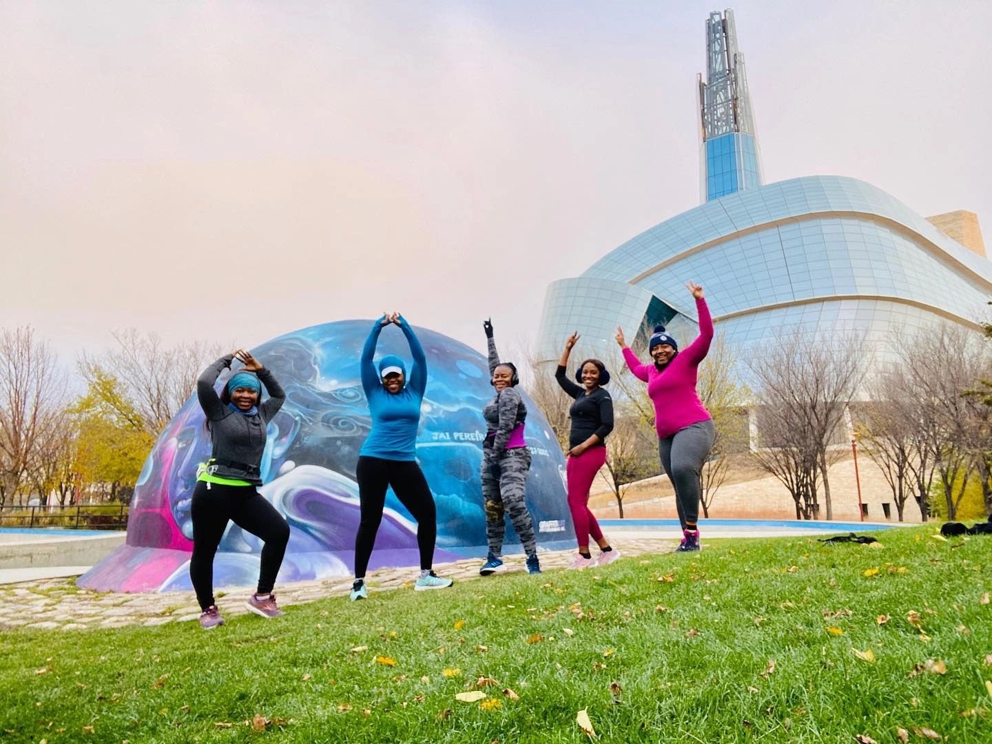 Pegcity Steppers women posing joyfully in front of a colourful mural